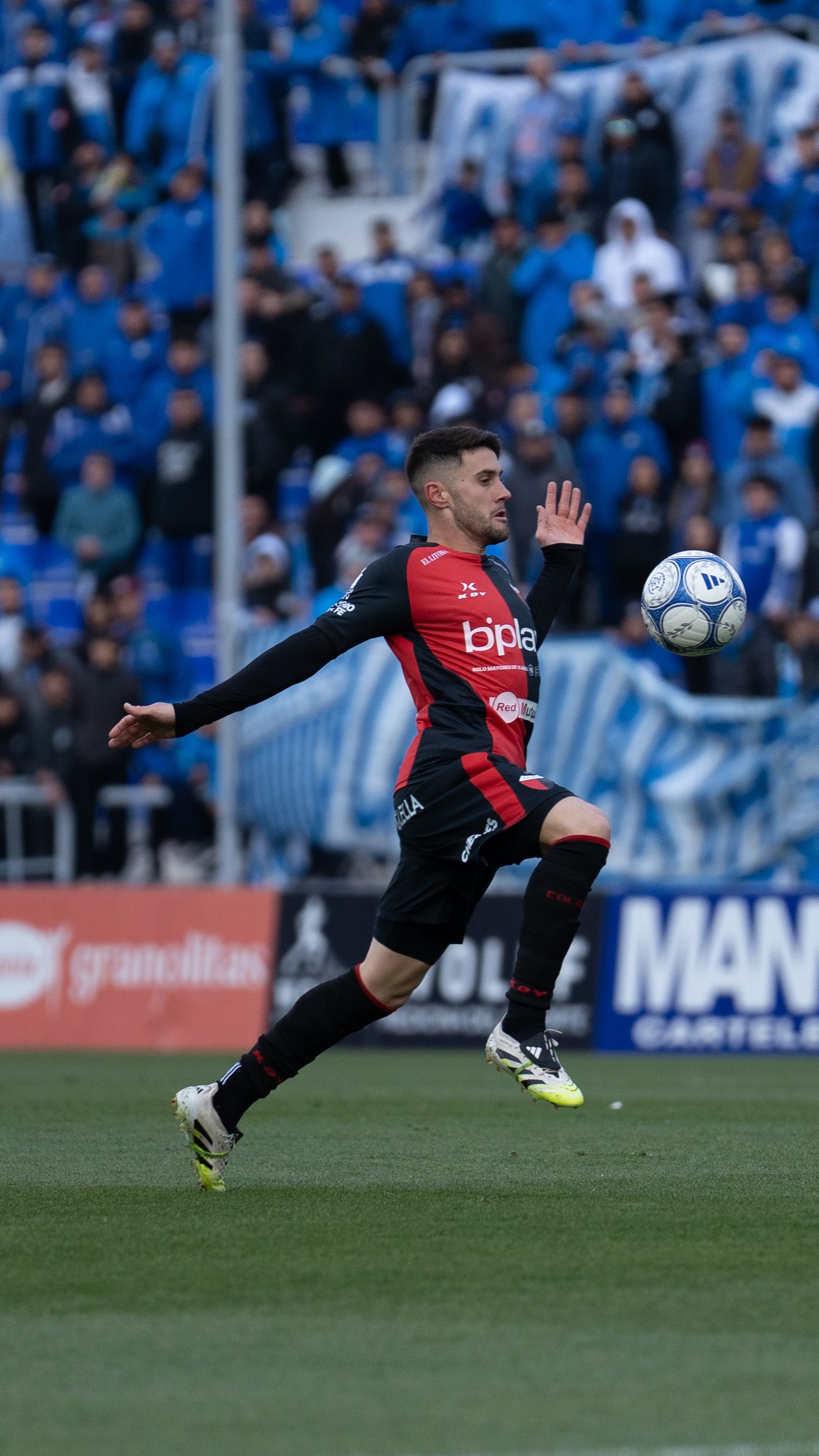 Dynamic soccer match with a player intercepting the ball on a lively stadium field.