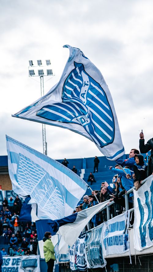 Free Vibrant crowd with flags cheering at a football stadium. Stock Photo