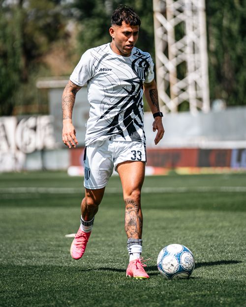 Free Young male soccer player in action on a sunny field wearing sports uniform and pink shoes. Stock Photo
