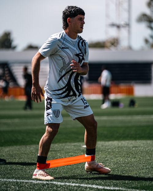 Free A soccer player practices with a resistance band on the field, enhancing strength and agility. Stock Photo