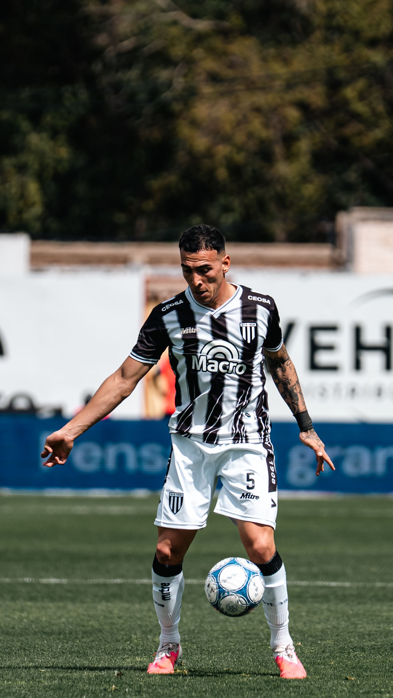 Dynamic shot of a soccer player controlling the ball during a sunny match day.