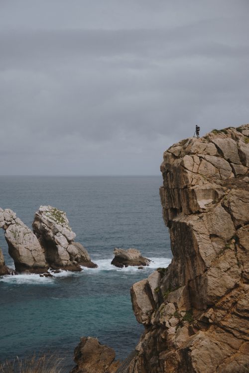 Free Person on cliff overlooking Cantabrian Sea in Santander, capturing adventure. Stock Photo