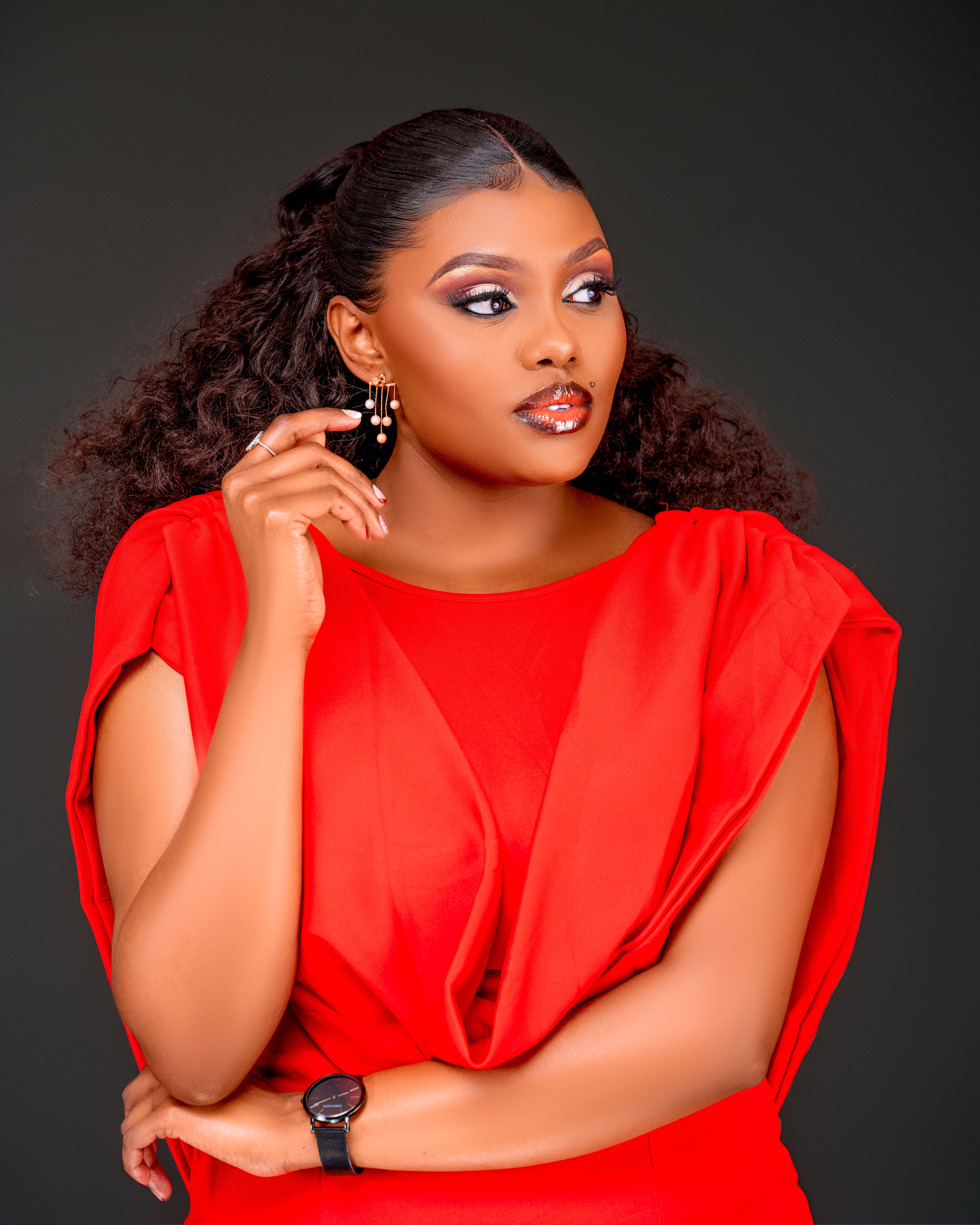Elegant woman in bright red dress exuding confidence and style.