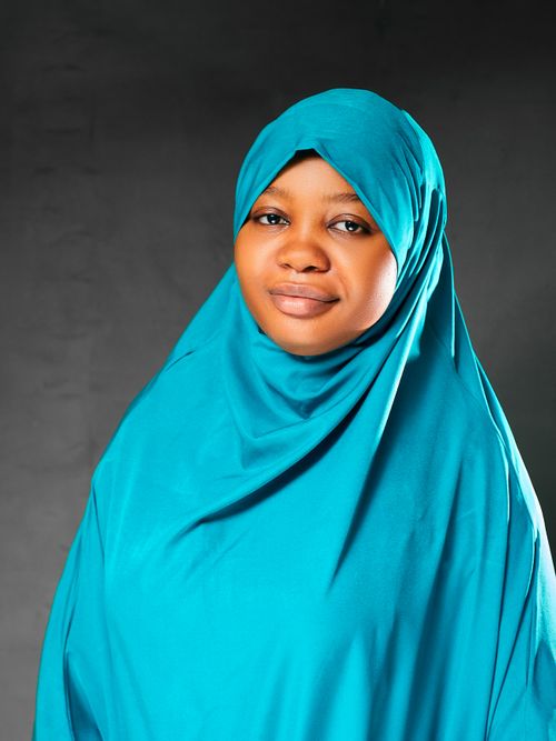 Free A woman in a blue hijab posing confidently against a neutral backdrop. Stock Photo