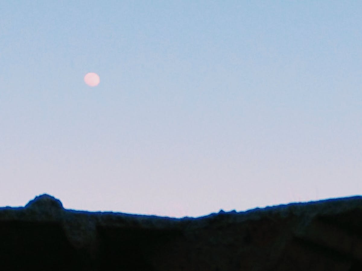 A simple desk setup with a laptop, notebook, and a phone placed out of reach