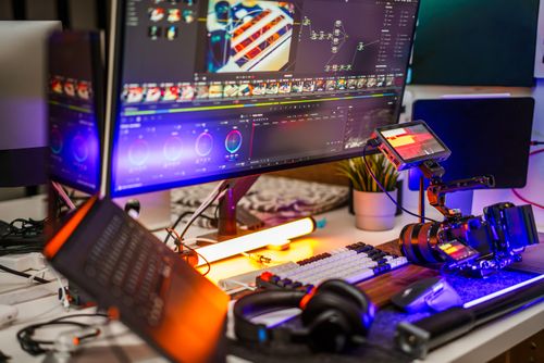 Free High-tech video editing workstation with camera gear and dual monitors. Stock Photo