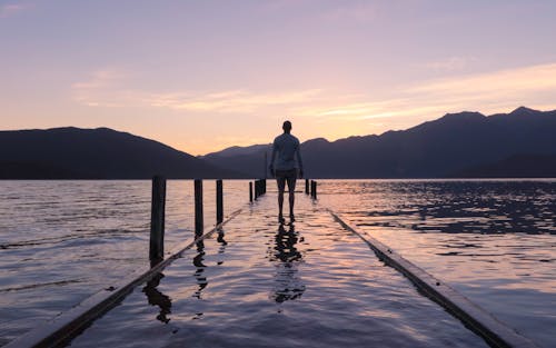 Free Person Standing on Dock With Water Stock Photo