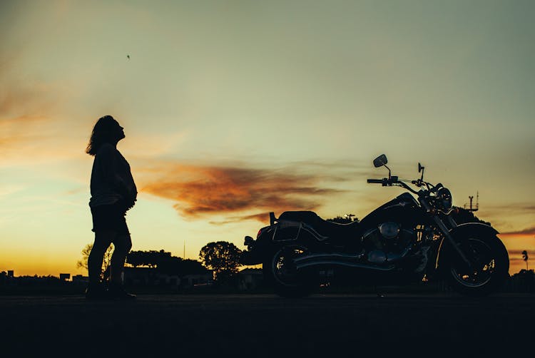 Silhouette Of Pregnant Woman Near Motorcycle During Sunset