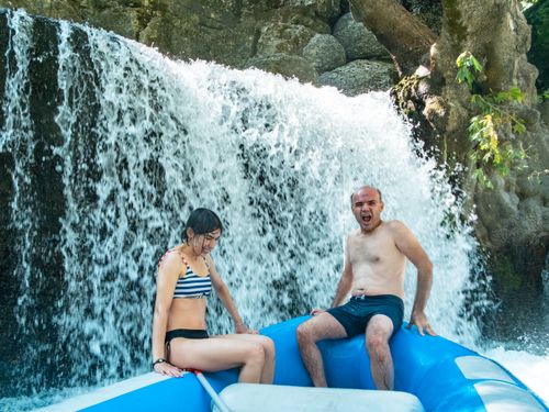 Free Two friends enjoying an exciting rafting adventure under a waterfall. Stock Photo
