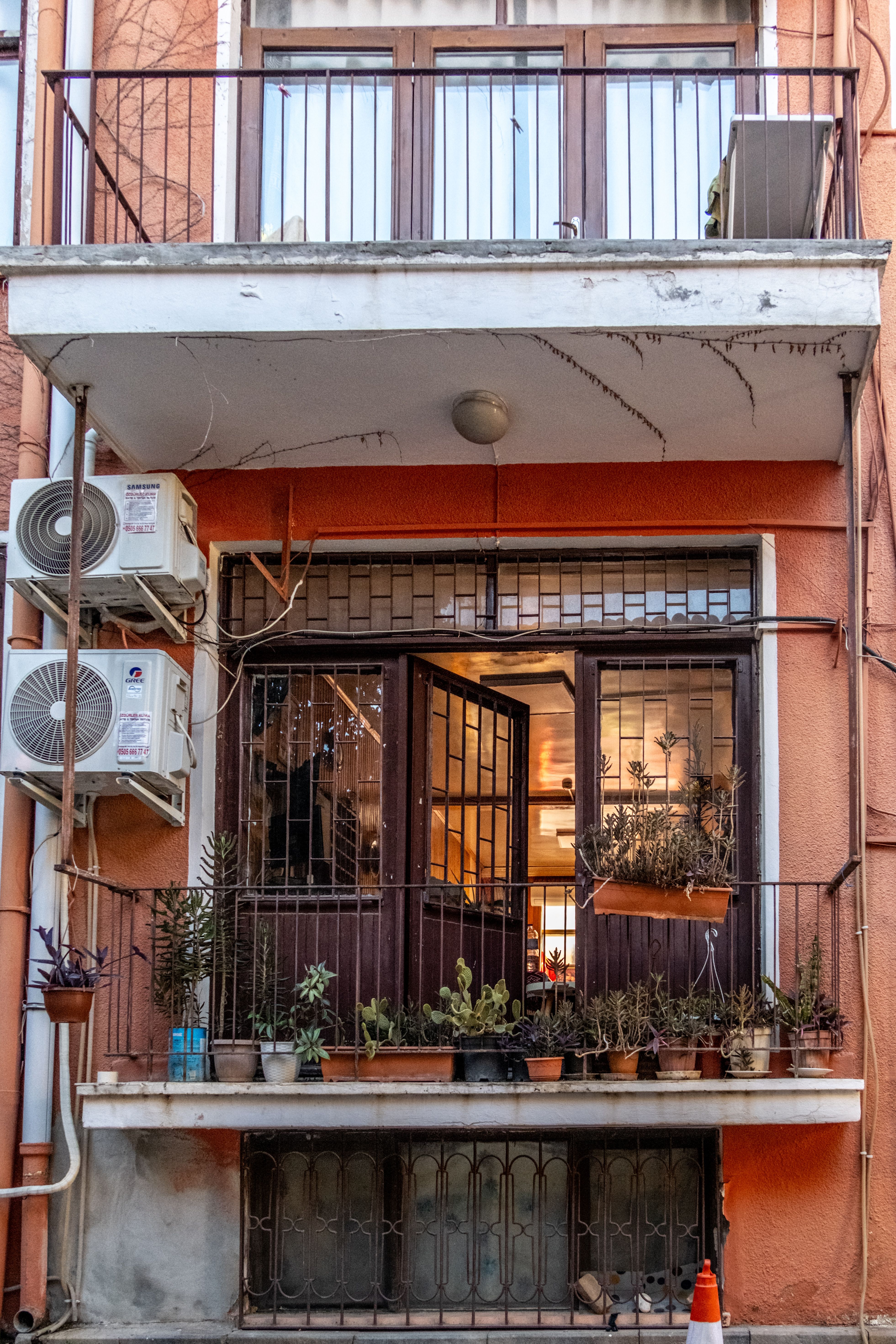 Adjustable railing planters with herbs and flowers on a small apartment balcony edge