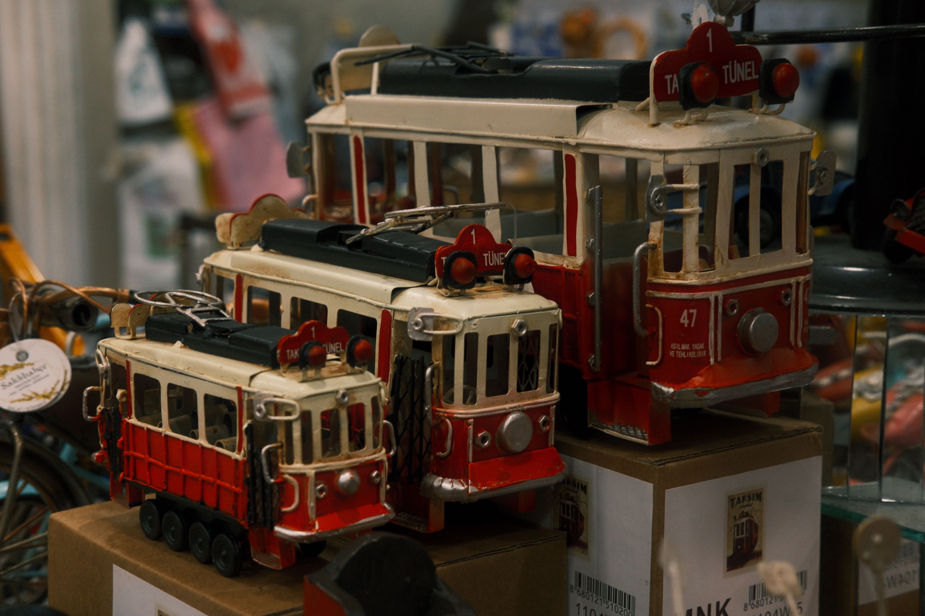 Charming display of miniature red trams in a vintage toy store, capturing nostalgic vibes.