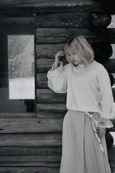 在日本的一间乡村小屋旁，一名身穿白色连衣裙的女子若有所思地站着