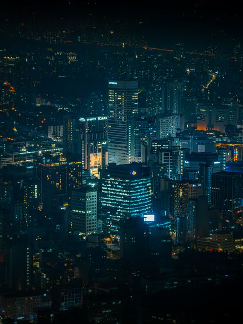 Free Stunning night view of Seoul's illuminated skyscrapers showcasing urban architecture and city lights. Stock Photo