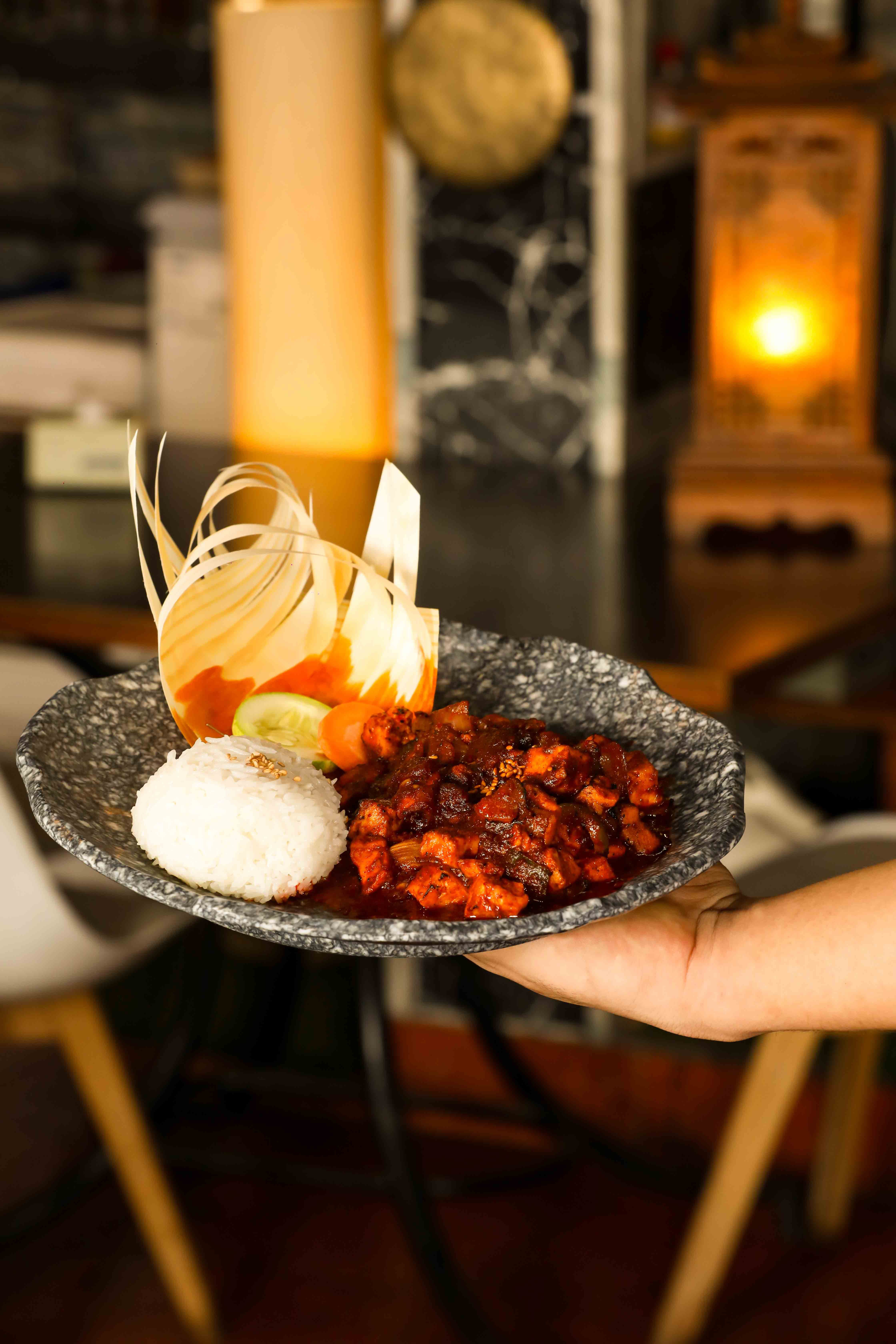 Gourmet dish with rice and vegetable garnish served indoors, highlighting elegant presentation.