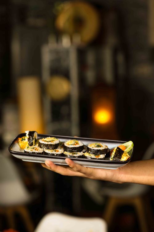 Free Artistic close-up of sushi on a platter in a cozy restaurant environment. Stock Photo