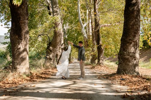 Free A couple dancing romantically on a tree-lined path in autumn. Stock Photo