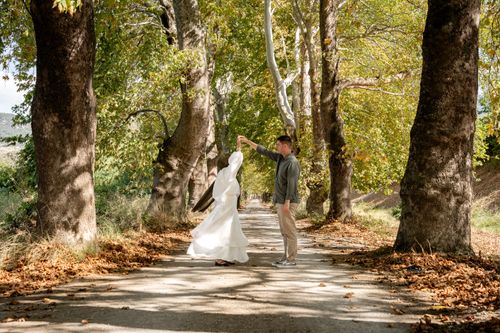 Free Couple dancing on a tree-lined path in a serene autumn setting. Stock Photo