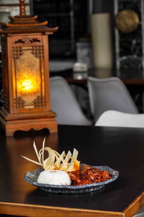 Free A stylish dish with rice and meat beside a decorative lantern in a restaurant. Stock Photo