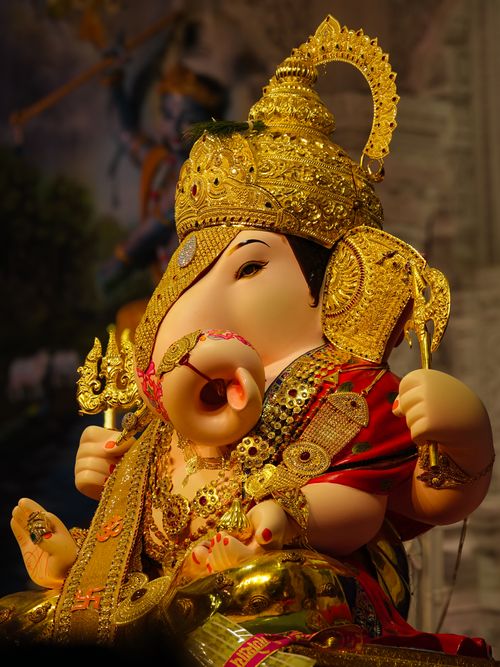 Free A beautifully ornate idol of Lord Ganesh, richly decorated with gold jewelry, captured in Pune, India. Stock Photo