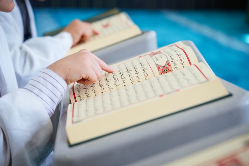 Anak membaca Al-Quran di ruang belajar