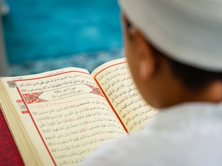 Child reading the Holy Quran with Tajweed