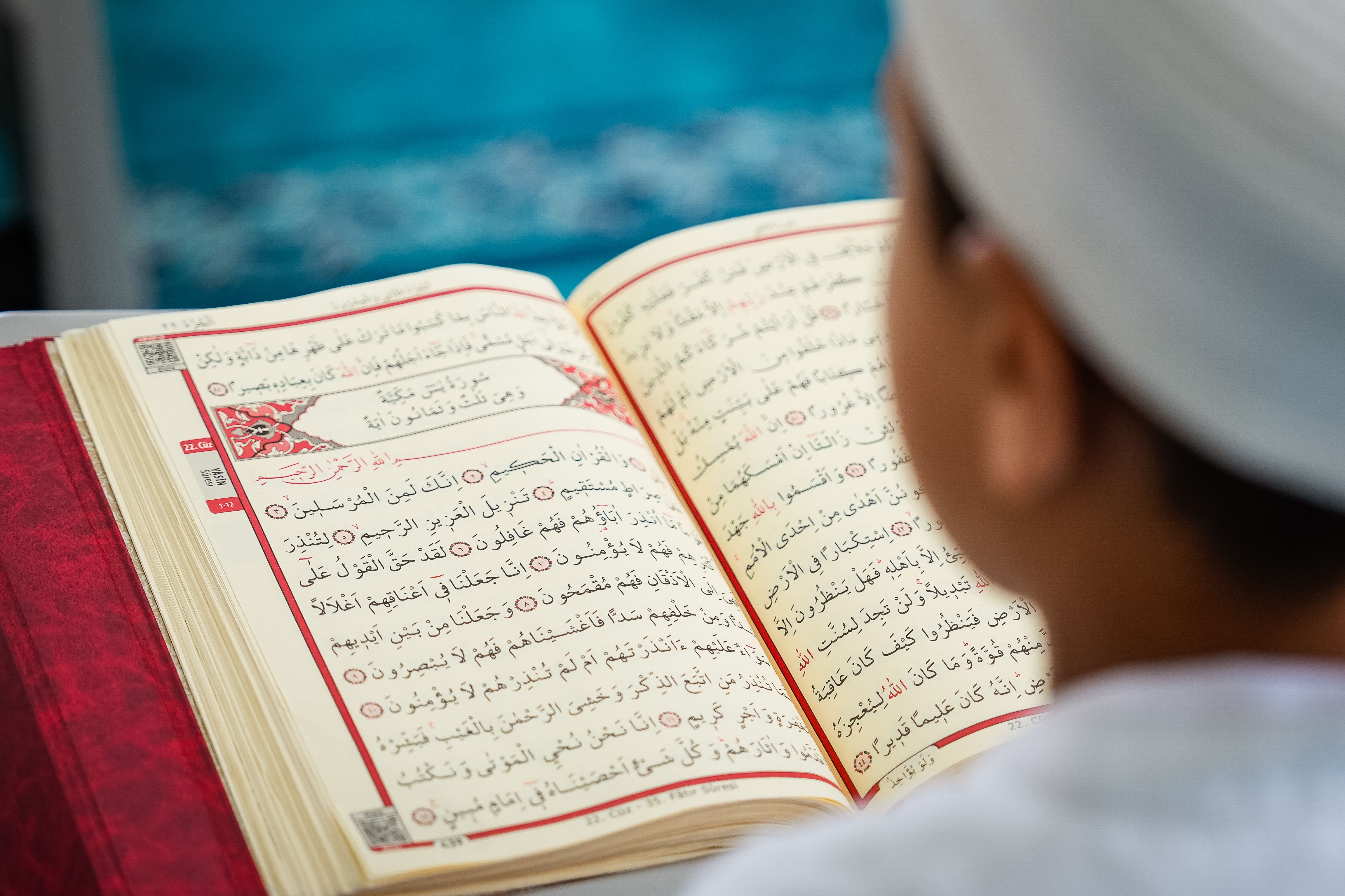 A young child reading the Quran inside a mosque, focusing on education and spirituality.