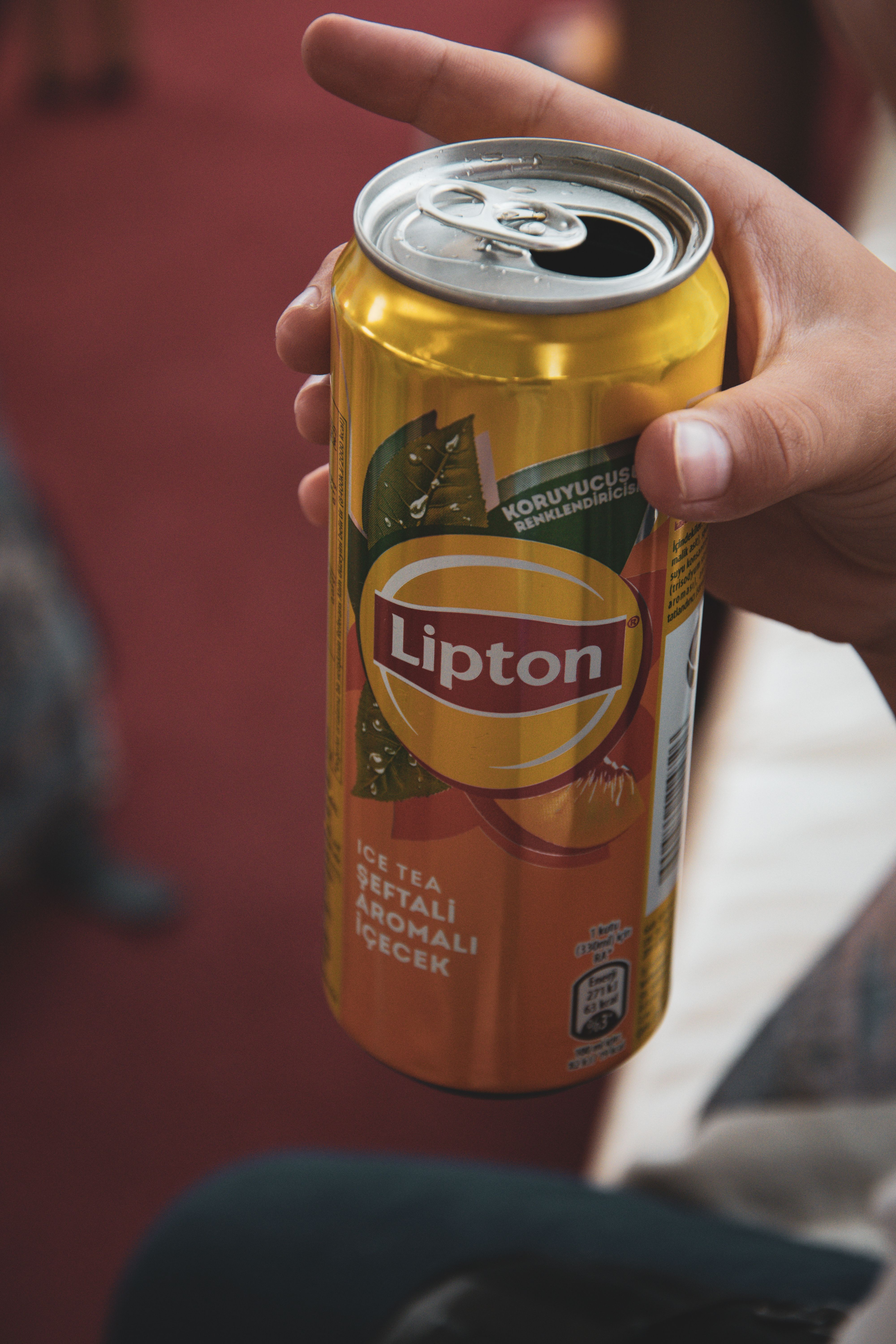 Hand holding a Lipton iced tea can in Türkiye, showcasing refreshing beverage branding.