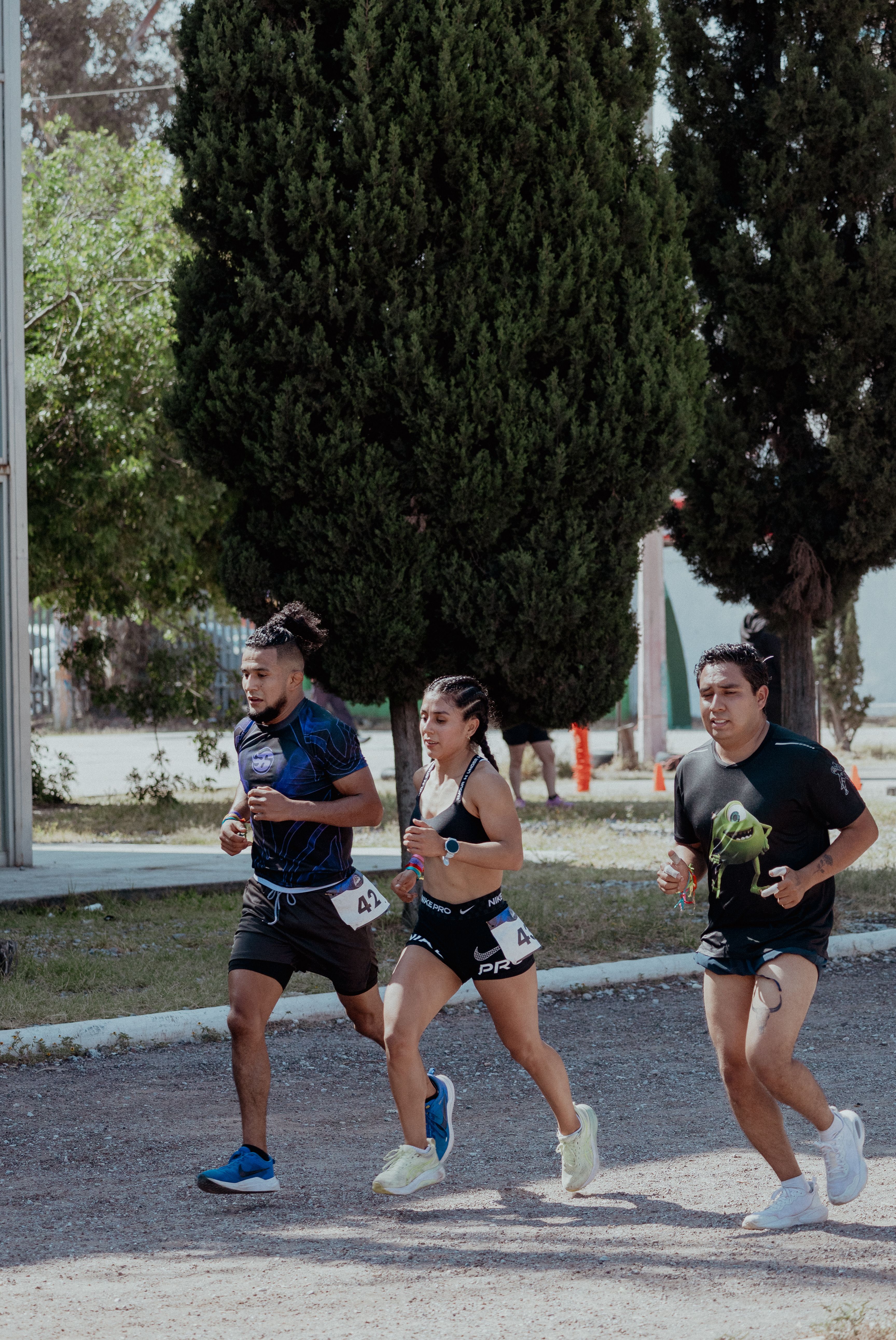 Three athletes engage in outdoor running competition in San Luis Potosí, showcasing teamwork and fitness.