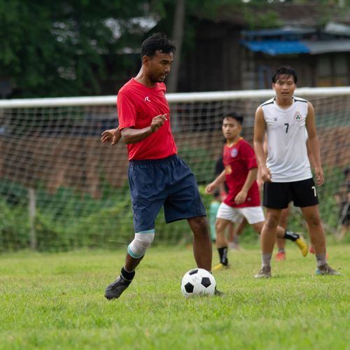 Free Amateur football game featuring young men playing passionately in Myawaddy, Myanmar. Stock Photo