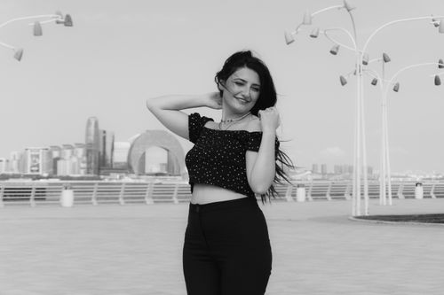 Free Black and white portrait of a smiling woman outdoors in Baku with cityscape background. Stock Photo