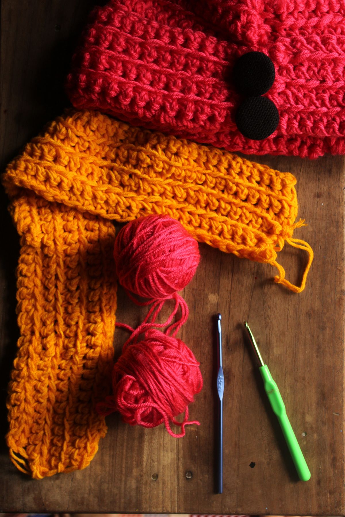 Cozy crochet setup featuring vibrant yarns and hooks on a warm wooden surface.