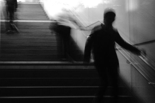 Free A blurred black and white photo showing silhouettes on a staircase. Stock Photo