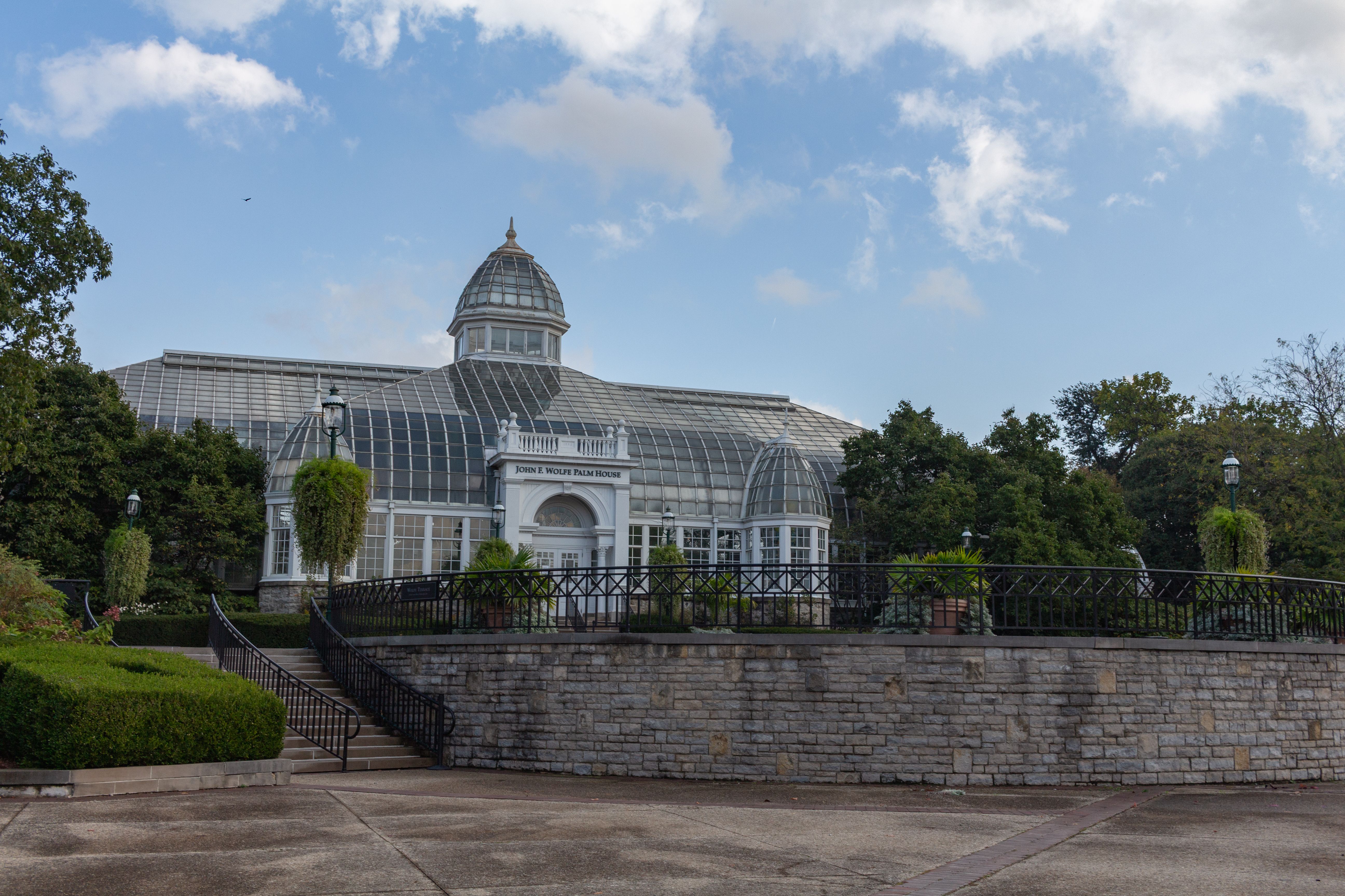 Capture of the glass palm house at Franklin Park Conservatory under a blue sky.