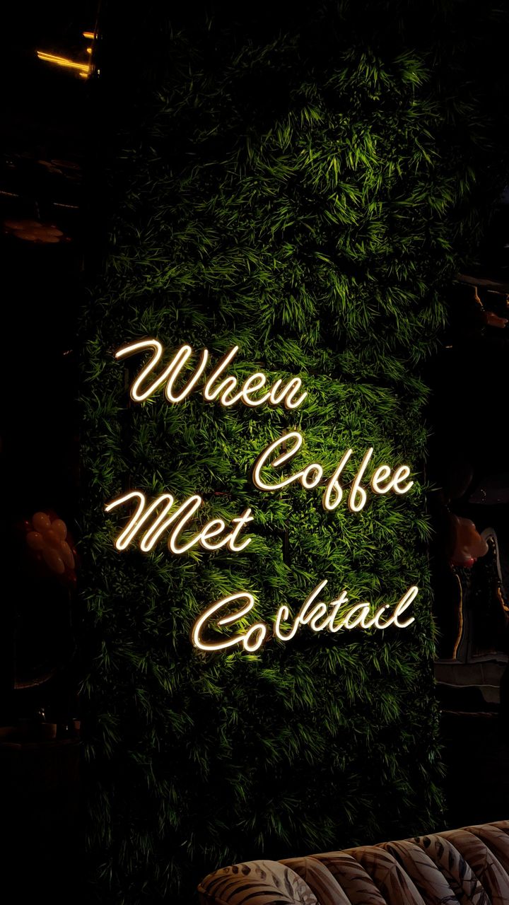 Colorful neon coffee sign mounted on the wall above a retro diner style coffee bar