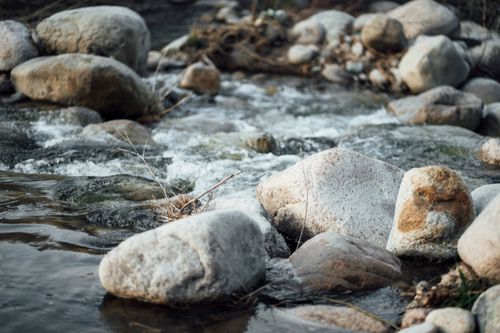 Free Peaceful flowing river with natural stones, capturing the serene beauty of Samarkand, Uzbekistan. Stock Photo