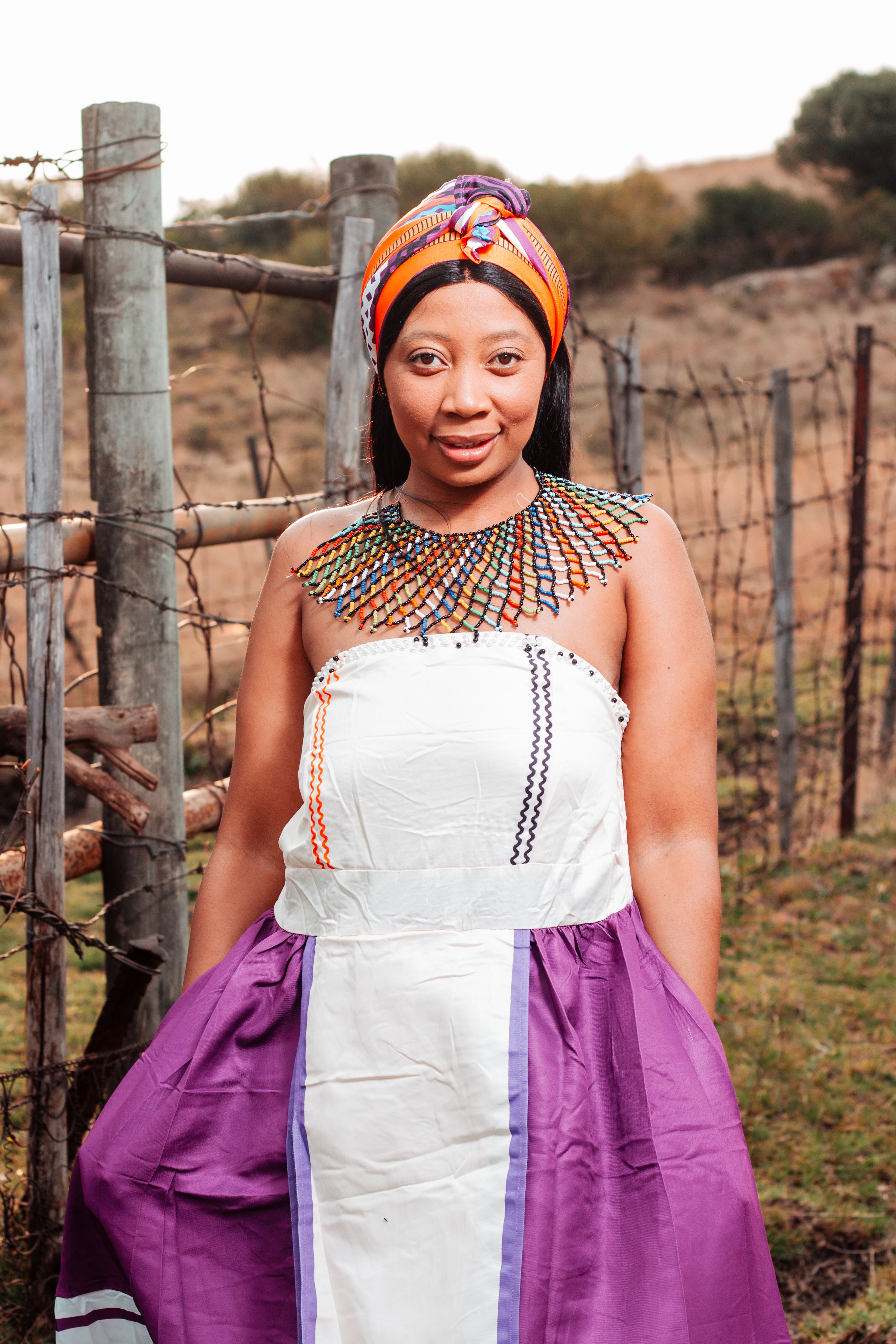 Woman in traditional Xhosa dress standing outdoors in Winburg, Free State.