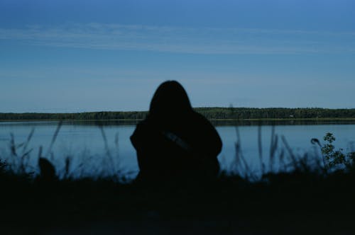 Free Person Sitting Near Lake Stock Photo