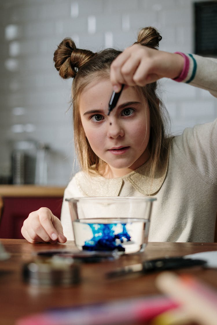 Girl Dropping Blue Dye On Bowl With Water