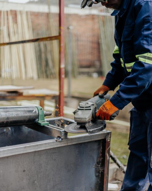 Free A construction worker uses an angle grinder in an industrial outdoor setting. Stock Photo
