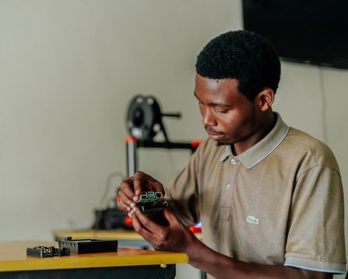 Free Focused man assembling an electronic circuit board at a desk, highlighting innovative technology and concentration. Stock Photo