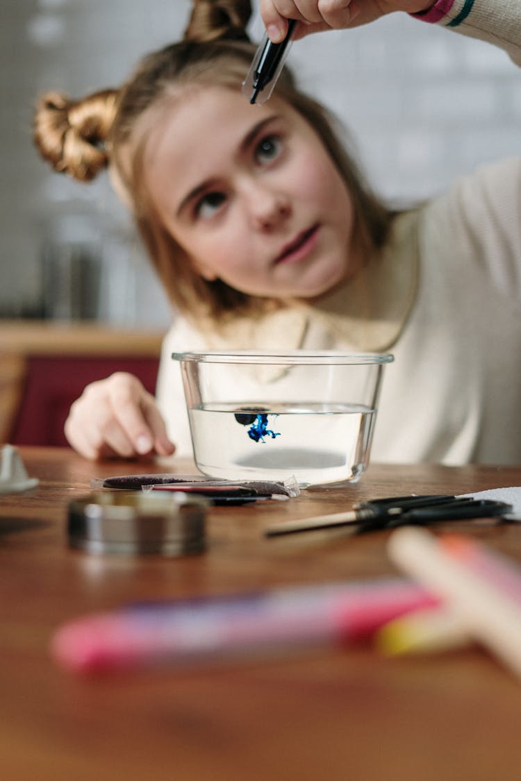 Girl Dropping Blue Dye On Bowl With Water