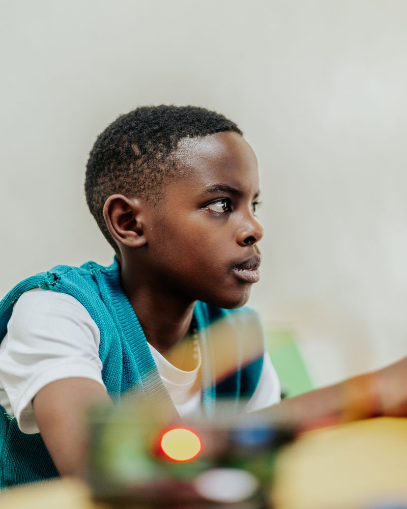 A young student focused on a screen during a build session