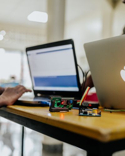 Laptops and a microcontroller on a workbench