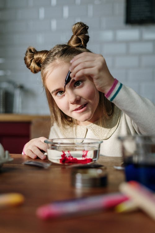 Girl Mixing Colors in Bowl with Water