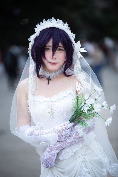 Free A cosplayer dressed as a bride in exquisite white lace with a bouquet, embodying elegance. Stock Photo