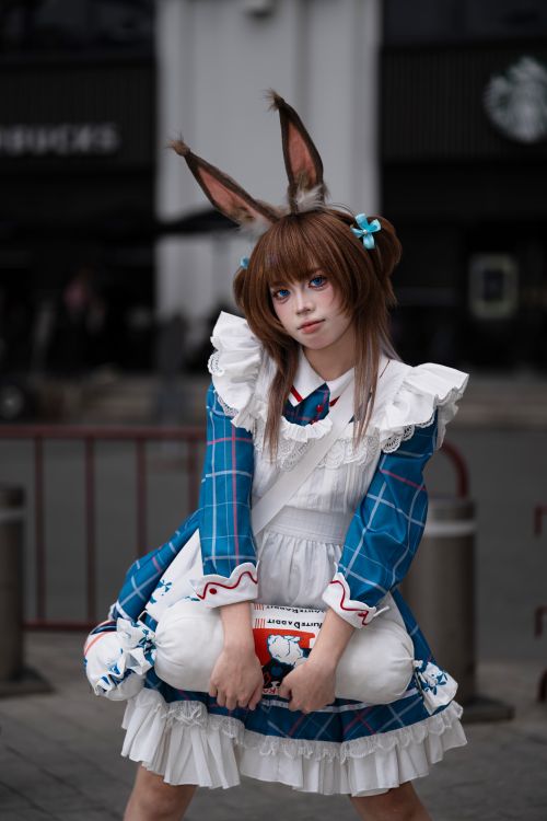 Free Person in a blue dress and bunny ears, representing cosplay in an urban setting. Stock Photo
