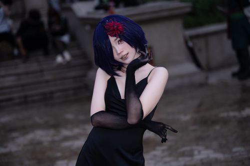 Free A stylish cosplay figure in a black dress with blue hair and a red flower accessory posing outdoors. Stock Photo