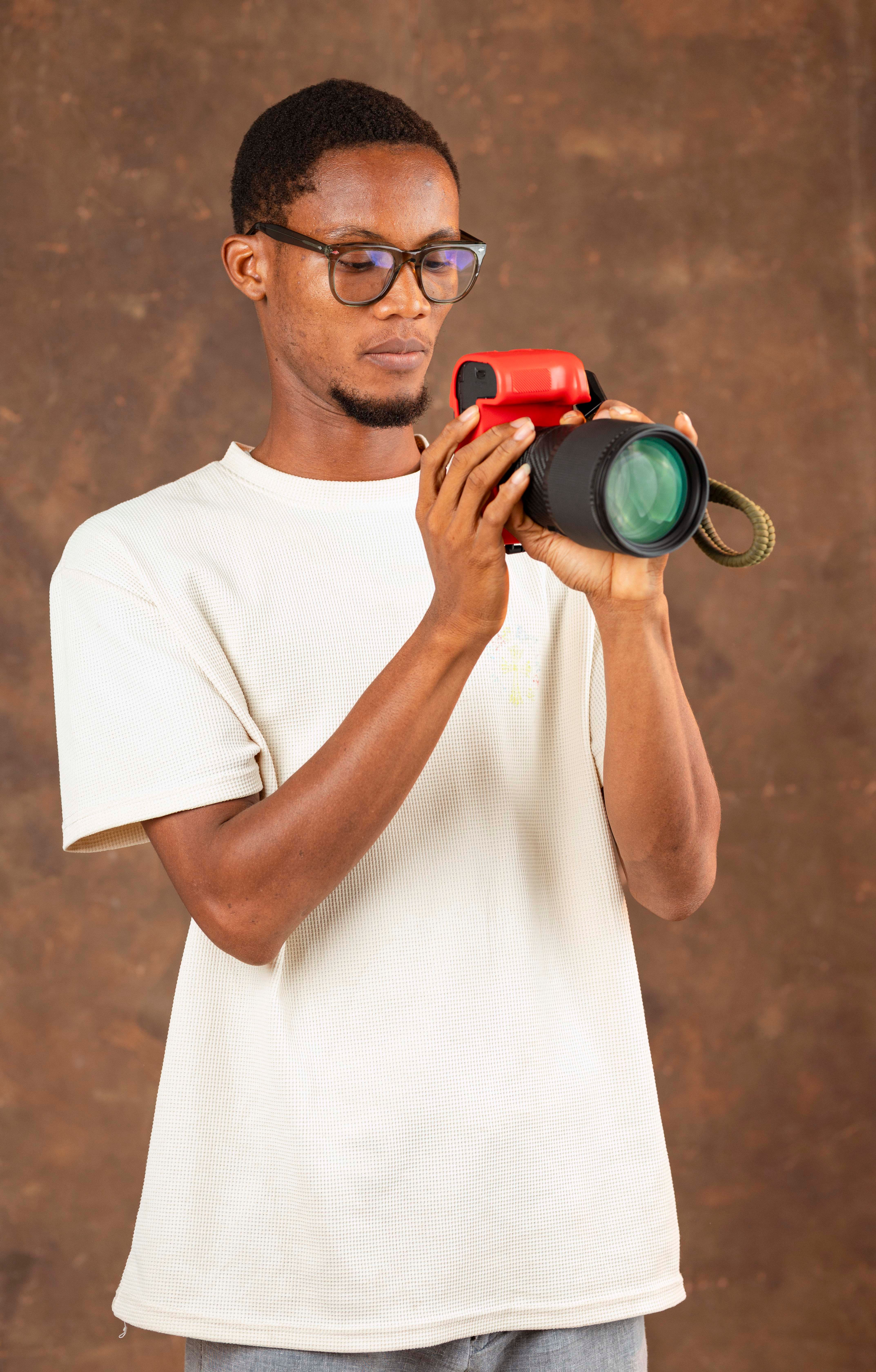 Man holding a camera, preparing for a shoot in a photo studio.