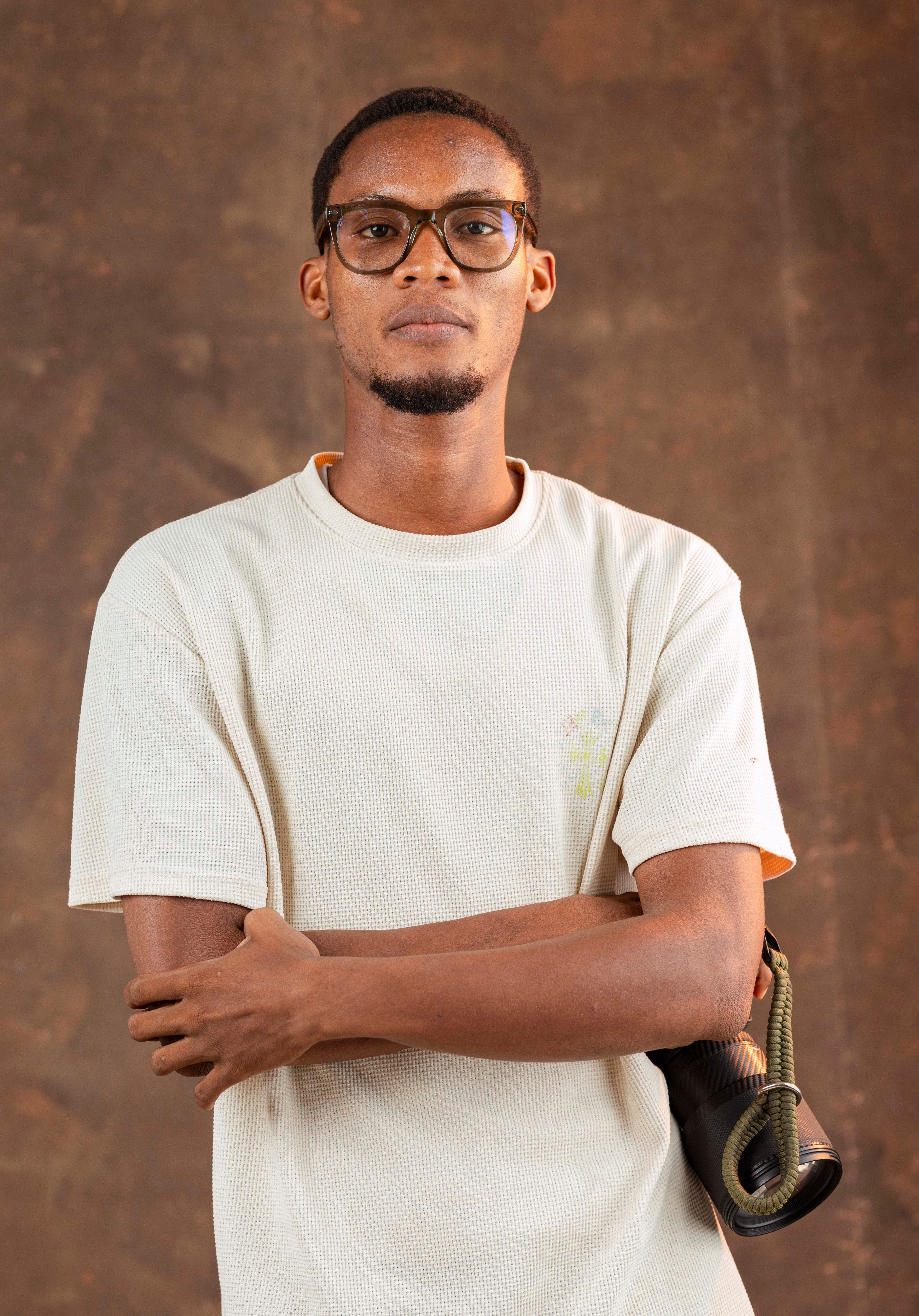 Portrait of a man in casual wear with glasses, captured in a studio in Accra, Ghana.