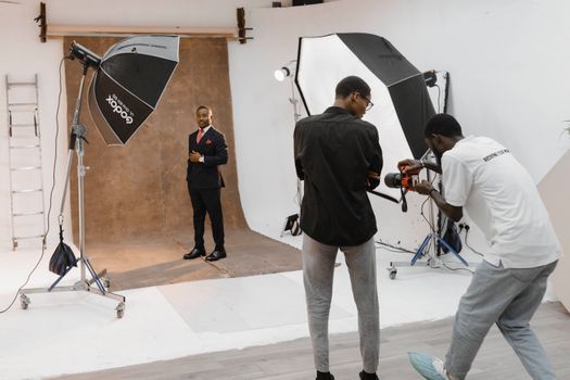 A professional photography session in a modern studio with photographer and subject. - Fotografer Sidoarjo
